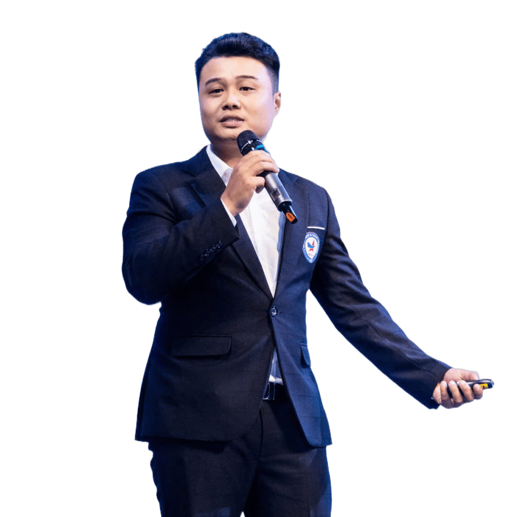Remove the background completely from this portrait photo. Keep ONLY the person: a Vietnamese man in a dark navy/black blazer and white shirt, holding a microphone, standing and presenting. The background must be 100% transparent (PNG with alpha channel). Preserve clean, sharp edges around the subject's hair, face, shoulders, hands, suit, and shoes. Full body from head to feet intact. Do not change the person's appearance, lighting, or colors in any way.